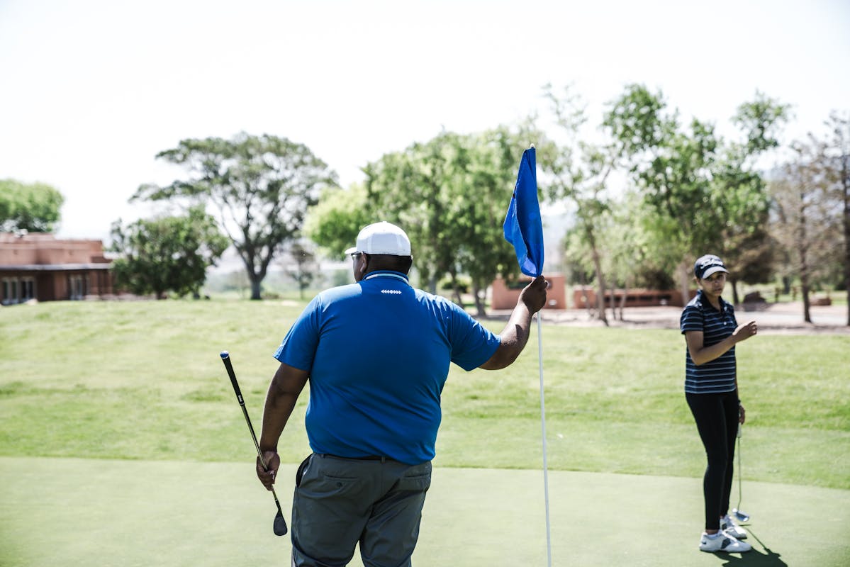 Soleil, performance et confort : la casquette de golf passée au crible Two golfers enjoying a game on a sunny golf course, focusing on recreation and leisure.